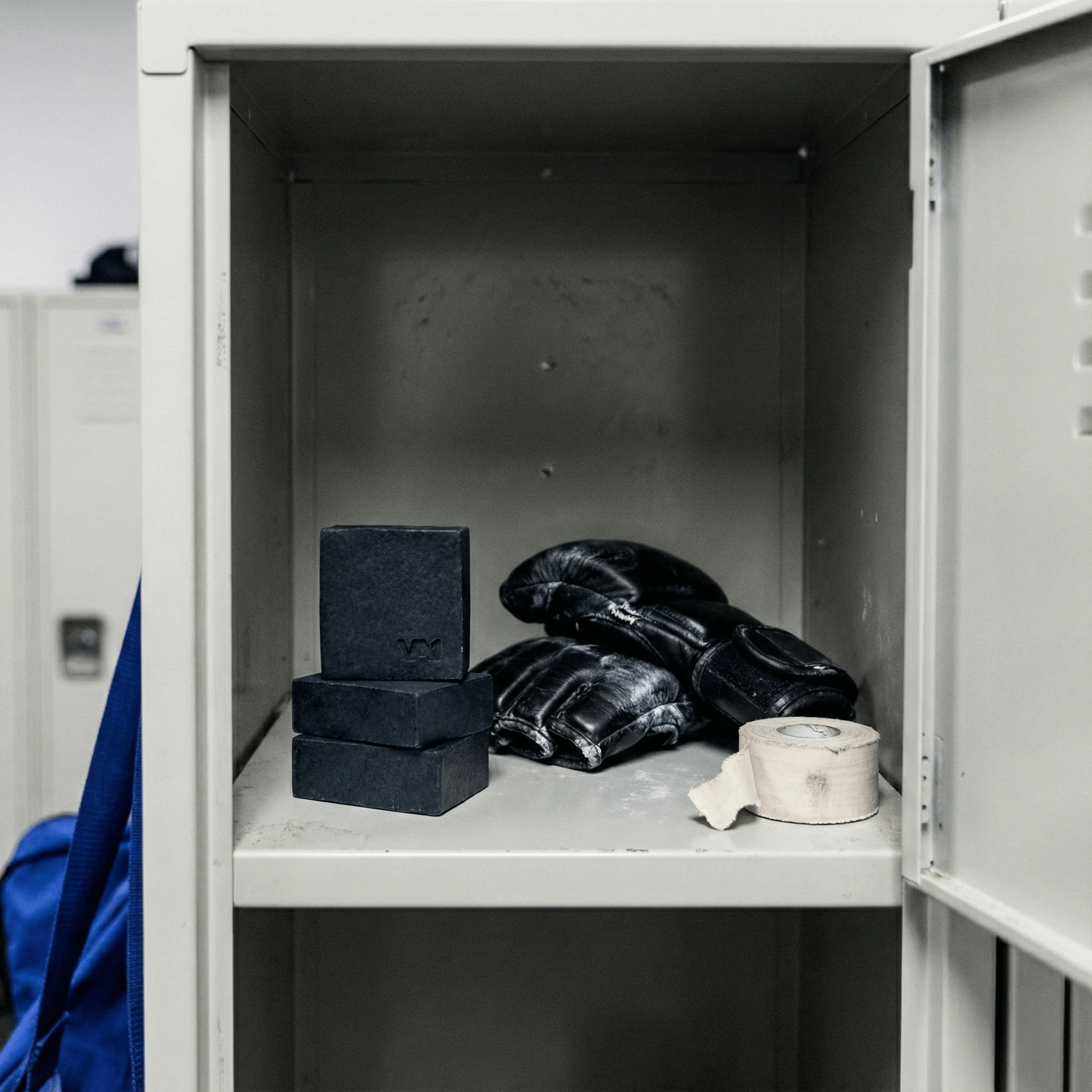 3er-Stapel VA1 Core Bar im Spind neben gebrauchten MMA Handschuhen und Tape. Hygienische Aufbewahrung der Mat Defense Ausrüstung im Locker Room.