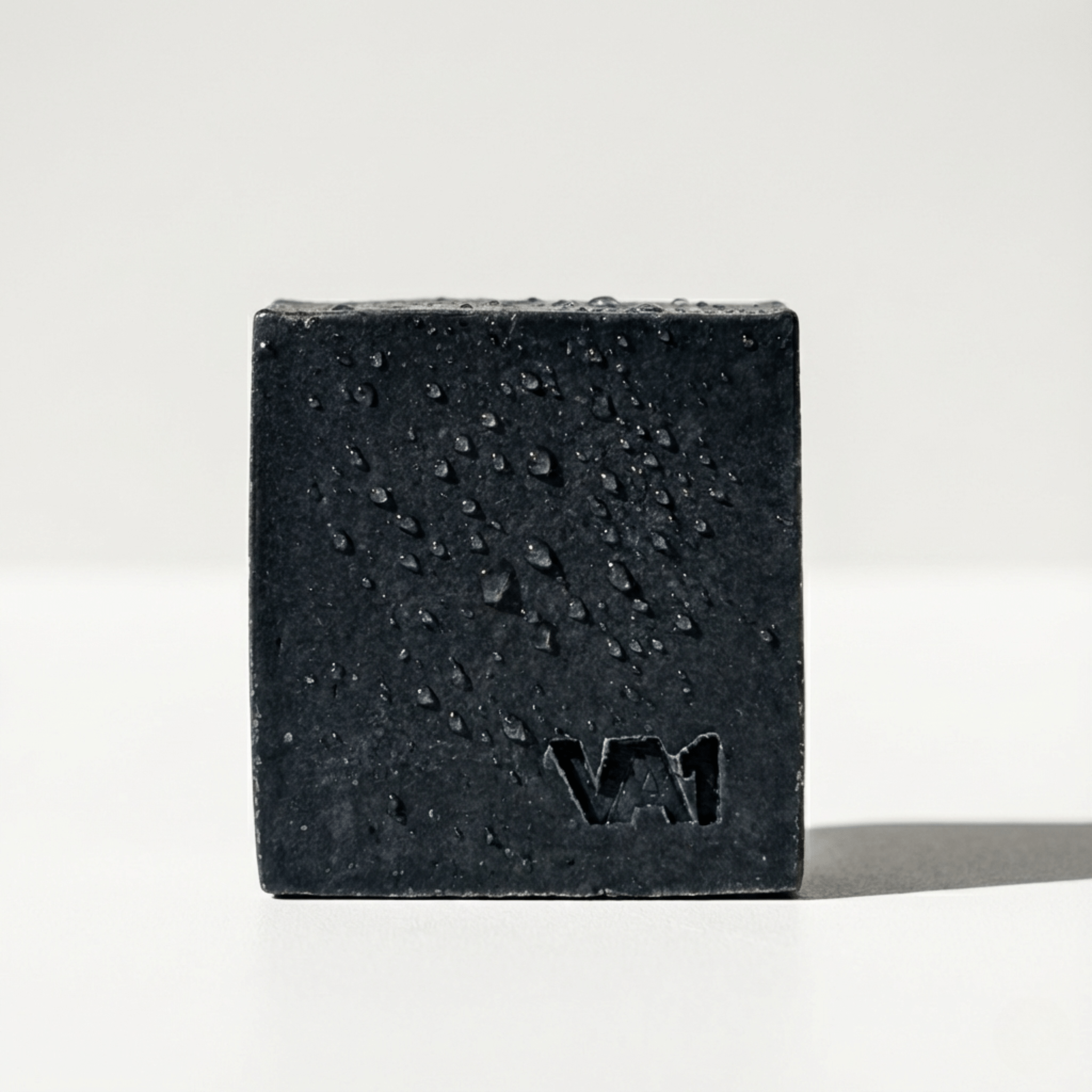 Nahaufnahme der VA1 Core Bar: Matte, schwarze Aktivkohle-Seife mit eingeprägtem Logo und sichtbarer Oberflächenstruktur.
