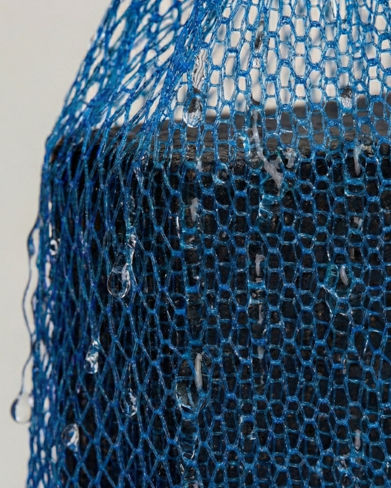 Makro-Aufnahme der nassen VA1 Seifenbeutel Netzstruktur. Detailansicht des Polyamid-Gewebes für mechanisches Peeling und hygienische Trocknung.