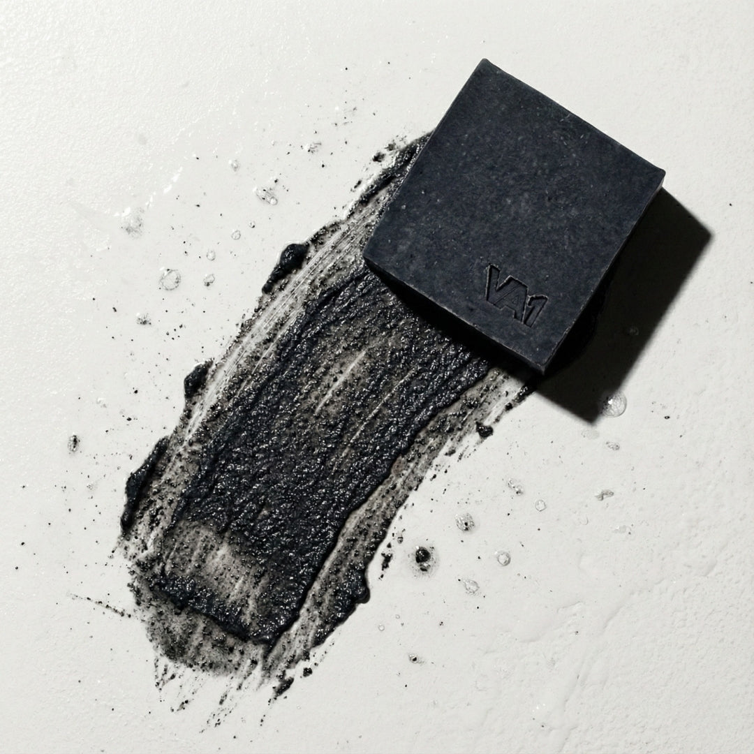 Smear-Test der VA1 Core Bar auf weißem Grund. Die körnige Textur des schwarzen Aktivkohle-Abriebs visualisiert die mechanische Peeling-Wirkung.